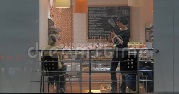 有手机的女人在咖啡馆里做朋友的照片视频的预览图