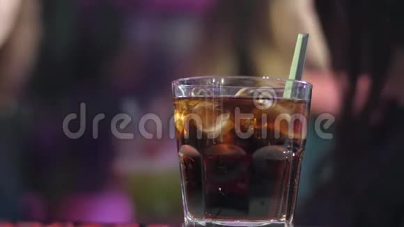 威士忌或白兰地放在杯子里酒吧柜台上的冰块在模糊的背景上视频的预览图