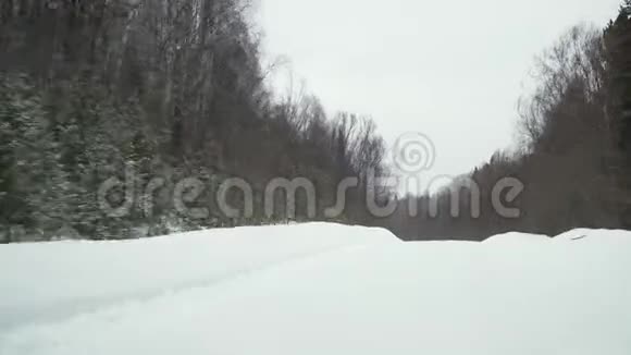 从前窗在冬季森林道路上行驶视频的预览图
