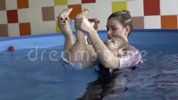 一个小孩和教练一起潜入水中视频的预览图