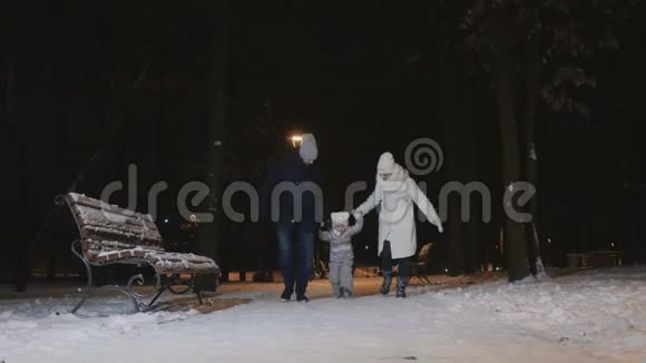 晚上公园一对年轻夫妇带着女儿在镜头前奔跑视频的预览图