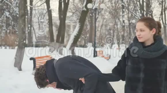 在冬天公园漂亮的女孩给一个打喷嚏的家伙喷鼻视频的预览图