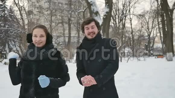帅哥们把雪球扔在冬天的公园里视频的预览图
