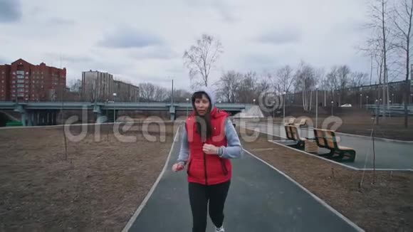 年轻女子在阴天在公园跑步视频的预览图