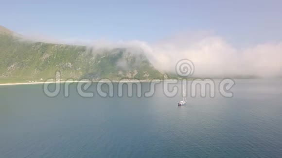 孤独的游艇在海湾和多云的山后视频的预览图