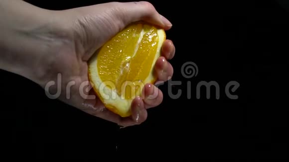 一个女人手从一个橙色的慢动作中挤出果汁视频的预览图