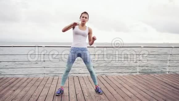 跑步的女人伸展身体做弓健身女运动员在海滩上放松在做有氧运动前做热身运动视频的预览图