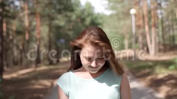 一个穿蓝色连衣裙的女孩正在公园里散步视频的预览图