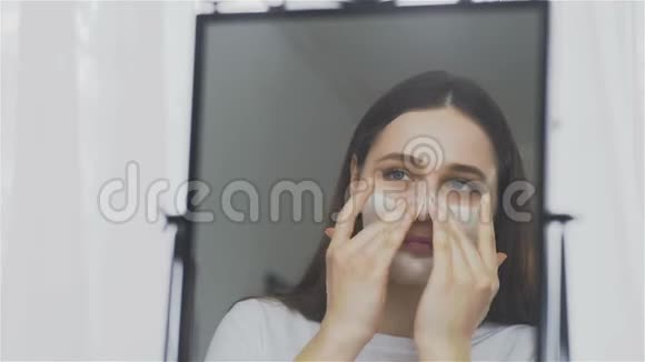 女人敷面膜保湿护肤霜在脸上照镜子视频的预览图