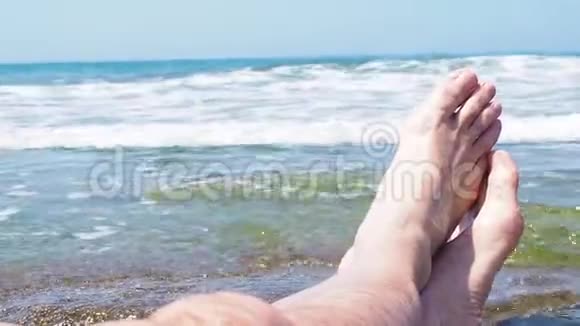 沙滩上的沙公脚第一人称在热带岛屿上观看腿部和海洋印度尼西亚巴厘岛视频的预览图