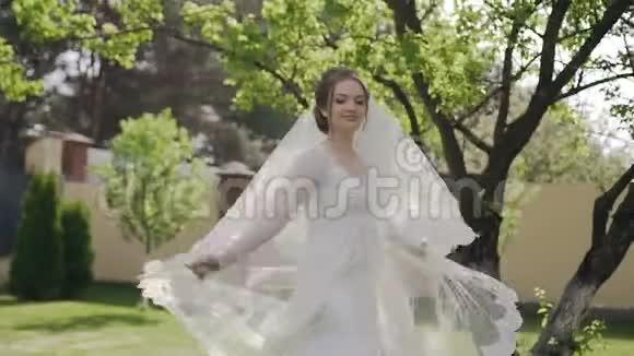 特写镜头美丽的新娘穿着漂亮的婚纱长长的花边在春天转悠散步视频的预览图