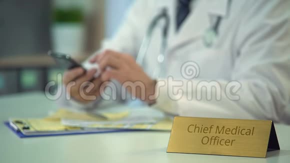 首席医疗官的手在诊所的智能手机上滚动页面视频的预览图