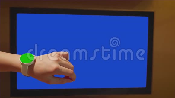 白色儿童手指按腕表上的触摸屏控制墙壁上的监视器近景视频的预览图