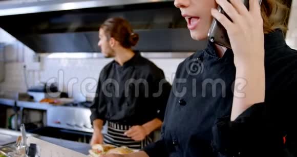 女厨师一边看剪贴板一边打电话4k视频的预览图