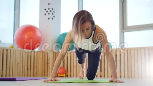 年轻女子健身教练在工作室做俯卧撑视频的预览图