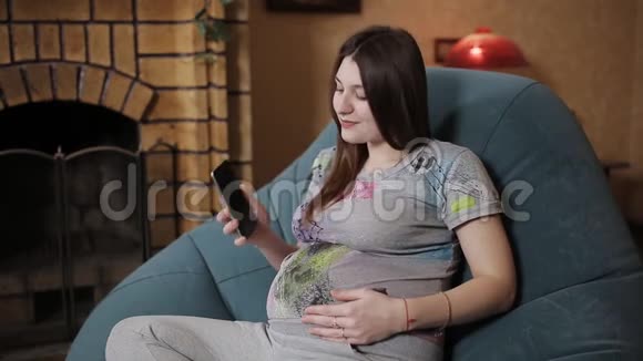 孕妇在家打电话坐在沙发上视频的预览图