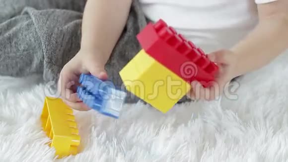 孩子的手是用白色背景上的彩色积木演奏出来的视频的预览图
