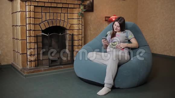 孕妇在房间里休息使用智能手机视频的预览图