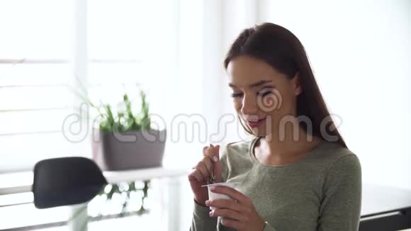 饮食营养吃天然酸奶的年轻魅力女人视频的预览图