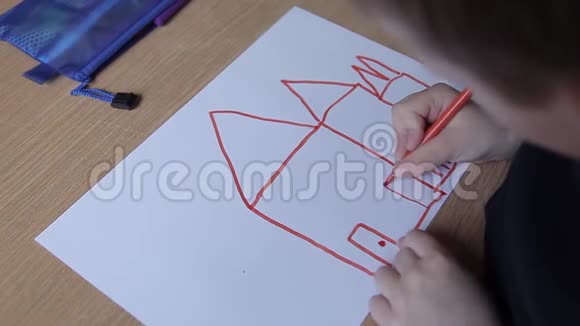 一个男孩用毛毡笔在纸上画房子视频的预览图