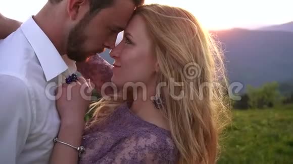 敏感的户外肖像美丽的幸福夫妇轻轻触摸鼻子在日落金发美女视频的预览图
