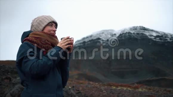 年轻女子正在外面喝杯咖啡欣赏美丽的山景视频的预览图