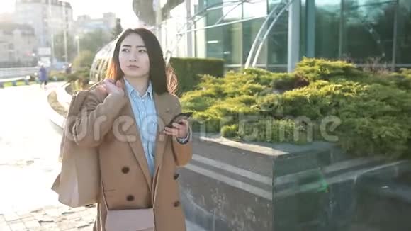 漂亮的亚洲女孩在手机上发短信视频的预览图