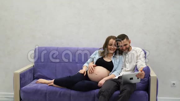 幸福的家庭夫妇坐在沙发上打电话给他们在另一个城市的父母告诉新闻视频的预览图