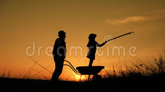 父亲和女儿的剪影与土地运输和耙子工具小规模有机农业视频的预览图