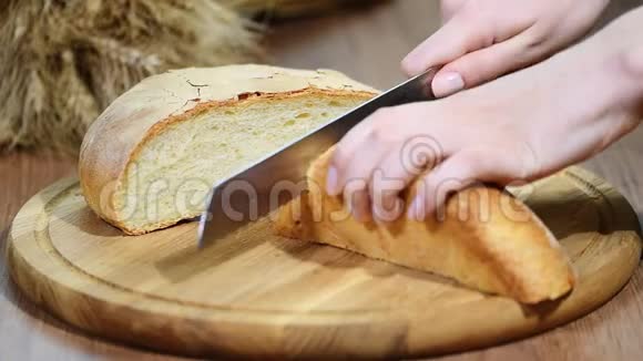 男性手在木板上切麦面包视频的预览图