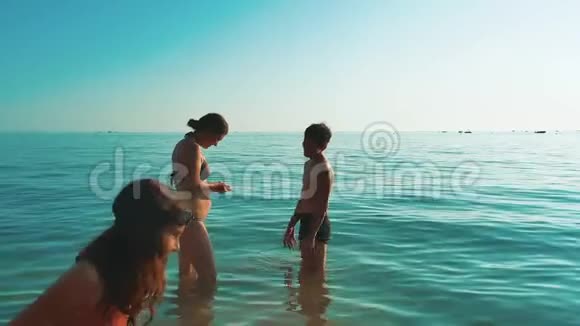 幸福的一家人在海洋里游泳母亲和孩子们在海里游泳生活方式视频的预览图
