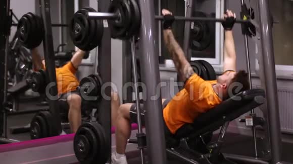 强壮有胡子的男人在健身房做板凳压视频的预览图