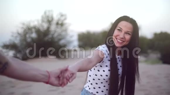 浪漫的概念年轻的夫妻双手赤脚在沙滩上奔跑女人牵着爱人的手向前奔跑视频的预览图