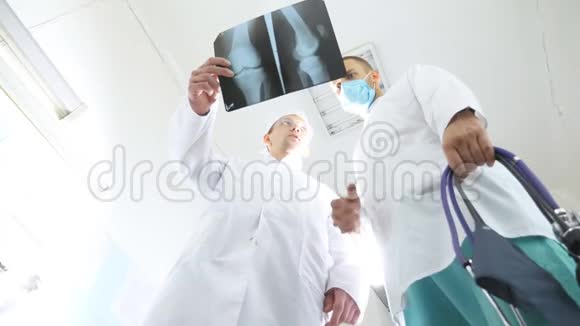 两位白种人医生观看核磁共振成像并讨论了这个问题医务人员在医院检查x射线指纹男性视频的预览图