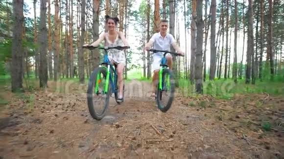 白种人年轻夫妇在森林里享受骑自行车的乐趣视频的预览图