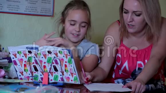 妈妈帮女儿做作业女孩做功课读书写作视频的预览图
