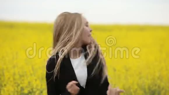少女在盛开的黄色田野里跳舞视频的预览图