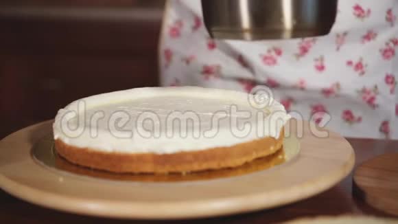 糕点厨师正在用鲜奶油在蛋糕上涂上樱桃果酱视频的预览图