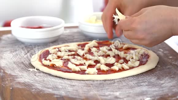 准备披萨厨师把奶酪倒在披萨上特写镜头视频的预览图