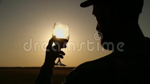 农夫喝一杯白葡萄酒又是日落的天空无法辨认的男性手拿着酒杯在露台上贷款视频的预览图