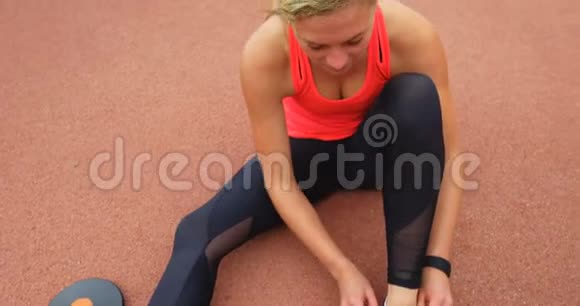 4k跑道上系鞋带的女运动员视频的预览图