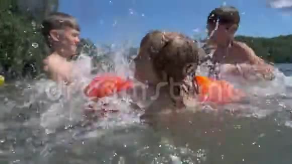 三个活跃的男孩在水里溅起水花视频的预览图
