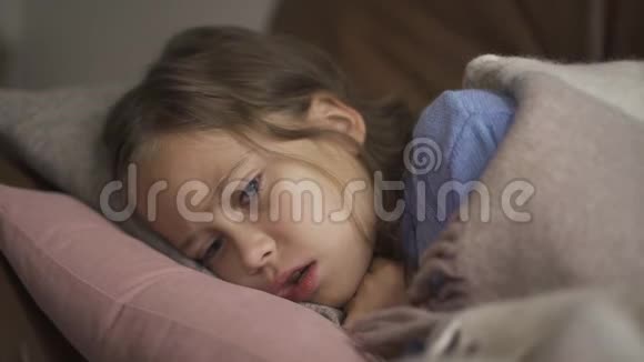 生病的年轻白种人女孩在家里躺在毯子下咳嗽这孩子发烧了健康疾病概念视频的预览图