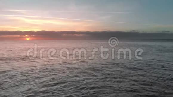 空中射击日出在海洋上空太阳出现在地平线上粉红色和橙色海洋岛波浪视频的预览图