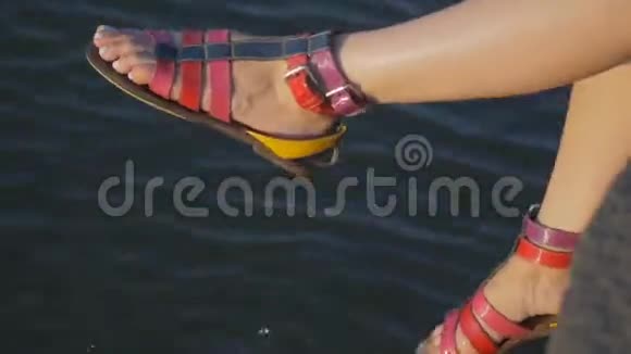 一个女孩的腿坐水边那个女孩穿着彩色凉鞋在水边喋喋不休视频的预览图