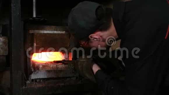 在锻造厂用金属制造剑铁匠从炉子里抽出铁水毛坯视频的预览图