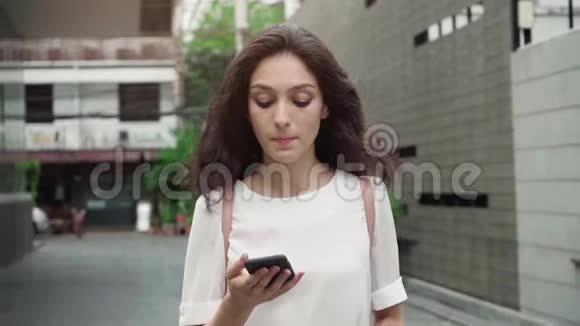 女孩走在城市街道上喝着咖啡以超慢的速度前进视频的预览图