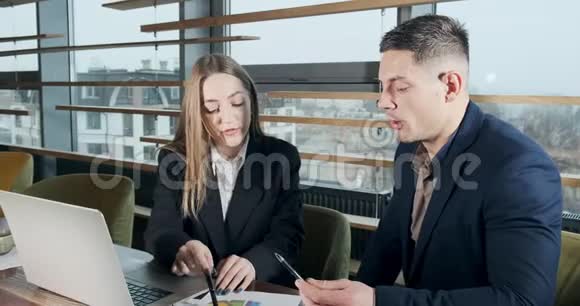 男人和女人在灯火通明的现代办公室里讨论工作从事手提电脑工作的有关男性和女性视频的预览图