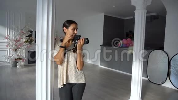 女摄影师与dslr相机在摄影棚与豪华内部视频的预览图