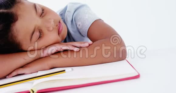 疲倦的女学生睡在书上视频的预览图